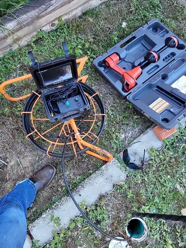 Professional drain camera equipment beside a residential cleanout