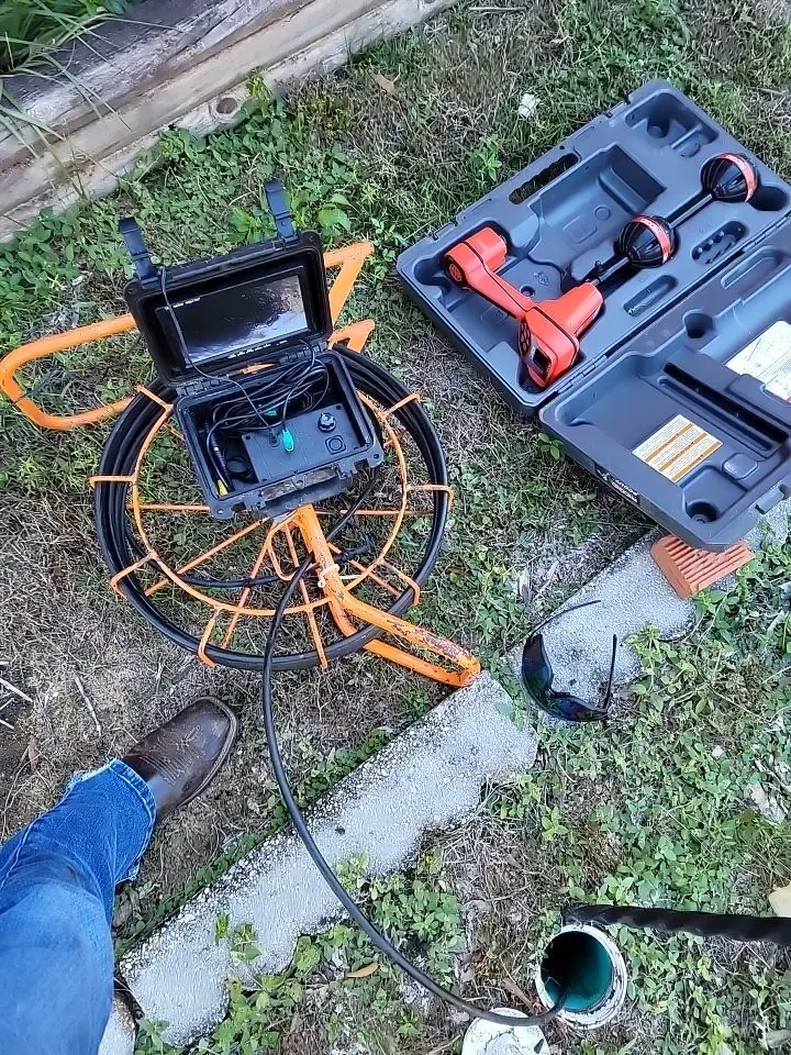 Professional drain camera equipment beside a residential cleanout